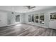 Open living area with gray wood floors, a ceiling fan, and a door to the outside at 234 S Central Ave, Apopka, FL 32703