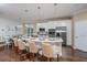Bright kitchen featuring a large center island with seating, modern stainless appliances, and adjacent dining area with bench seating at 2408 Juniper Berry Dr, Minneola, FL 34715