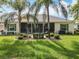 A spacious backyard featuring lush green lawn, mature palm trees, and a screened-in patio for outdoor enjoyment at 24112 Robinwood St, Leesburg, FL 34748