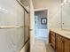 Bathroom with tub and sliding glass door, tile flooring, and wood vanity with cream countertop at 24112 Robinwood St, Leesburg, FL 34748