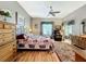 Cozy bedroom with a decorative ceiling fan, wood flooring, and lots of natural light at 24112 Robinwood St, Leesburg, FL 34748