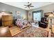 Comfortable bedroom with a ceiling fan, wood flooring, and a large window at 24112 Robinwood St, Leesburg, FL 34748