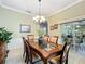 Formal dining room features a glass top table, chandelier and access to outdoor living at 24112 Robinwood St, Leesburg, FL 34748