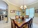 Formal dining room with decorative chandelier, glass table, and views of the outdoors at 24112 Robinwood St, Leesburg, FL 34748