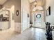 Bright foyer featuring tile floors and a decorative front door, leading to the kitchen area at 24112 Robinwood St, Leesburg, FL 34748