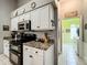 White cabinets, granite counters and black appliances complement the kitchen at 24112 Robinwood St, Leesburg, FL 34748
