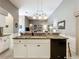 Close up on kitchen island with sink, granite countertop, white cabinets, and black dishwasher at 24112 Robinwood St, Leesburg, FL 34748