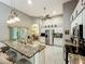 Open kitchen featuring granite counters, stainless appliances, tile floors, and access to the dining area at 24112 Robinwood St, Leesburg, FL 34748