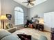 Living room featuring a large window, a workstation with two monitors, and comfortable seating at 24112 Robinwood St, Leesburg, FL 34748