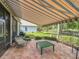 Covered patio with comfortable seating and manicured landscaping, providing a serene outdoor living space at 24112 Robinwood St, Leesburg, FL 34748
