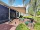 Inviting outdoor patio with awnings, brick flooring, and ample seating surrounded by well-maintained landscaping at 24112 Robinwood St, Leesburg, FL 34748