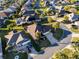 Aerial view showcasing a home with ample parking, lush landscaping, and proximity to neighborhood amenities at 2428 Maverick Way, The Villages, FL 32162
