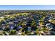 Expansive aerial view of a community featuring diverse homes, mature trees, and golf course views at 2428 Maverick Way, The Villages, FL 32162