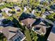 An aerial view of a neighborhood featuring well-maintained homes, lush landscaping, and mature palm trees at 2428 Maverick Way, The Villages, FL 32162