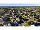 Wide aerial view of a neighborhood with established homes, lush landscaping, and mature trees in a community setting at 2428 Maverick Way, The Villages, FL 32162