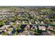 A neighborhood view shows homes interspersed with trees, ponds, and a golf course in the distance at 2428 Maverick Way, The Villages, FL 32162
