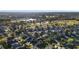 A stunning aerial showing a golf course, community lake, and houses surrounded by greenery at 2428 Maverick Way, The Villages, FL 32162