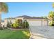 Attractive single-story home with a three-car garage, complemented by lush landscaping and a brick-paved driveway at 2428 Maverick Way, The Villages, FL 32162