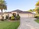 Beautiful single-story home featuring a three-car garage and a well-manicured front yard with mature palm trees at 2428 Maverick Way, The Villages, FL 32162