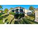 Exterior showcasing large windows, beautiful landscaping, and a well-maintained lawn at 2428 Maverick Way, The Villages, FL 32162