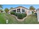 Exterior showcasing large windows, beautiful landscaping, and a well-maintained lawn at 2428 Maverick Way, The Villages, FL 32162