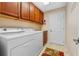 Laundry room featuring a white washer and dryer, and wood storage cabinets at 2428 Maverick Way, The Villages, FL 32162