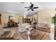 Open-concept living room leading to dining area and kitchen, featuring hardwood floors and comfortable seating at 2428 Maverick Way, The Villages, FL 32162
