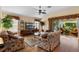 Cozy living room with hardwood floors, floral couches, and a ceiling fan at 2428 Maverick Way, The Villages, FL 32162