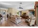 Bright living room with hardwood floors, floral couches, ceiling fan and windows at 2428 Maverick Way, The Villages, FL 32162