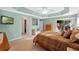 Main bedroom with tray ceiling, fan, light green walls, and carpet flooring at 2428 Maverick Way, The Villages, FL 32162