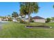 Spacious yard featuring lush green grass and mature palm trees at 2428 Maverick Way, The Villages, FL 32162