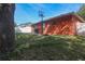 Home's backyard includes a concrete patio, grill, basketball hoop, and partial view of a fence at 2442 Foxhollow Rd, Tavares, FL 32778