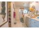 Coastal-themed bathroom features marble floors, vanity with oval mirror, and beach decorations, creating a relaxing oasis at 2442 Foxhollow Rd, Tavares, FL 32778