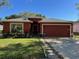 Charming single-story home with a well-manicured lawn, an attached garage, and a classic design at 2442 Foxhollow Rd, Tavares, FL 32778