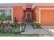 Inviting front entrance featuring vibrant landscaping, a charming fountain, and a warm colored exterior at 2442 Foxhollow Rd, Tavares, FL 32778
