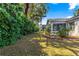 The backyard features mature landscaping that compliments the home's architectural style and screened in lanai at 2488 Ansley Path, The Villages, FL 32162