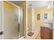 Bathroom view showcases the vanity with a shower and frosted glass doors to the left at 2488 Ansley Path, The Villages, FL 32162