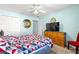 Cozy bedroom with a ceiling fan, a dresser with television, and an adjacent closet at 2488 Ansley Path, The Villages, FL 32162