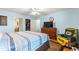 Comfortable bedroom features a ceiling fan, television, and a Green Bay Packers chair at 2488 Ansley Path, The Villages, FL 32162