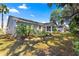 The side of the home is well-manicured, features a patio, screened lanai, and mature landscaping at 2488 Ansley Path, The Villages, FL 32162