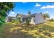 Exterior view of the home, showcasing the screened lanai and well-maintained lawn under a clear sky at 2488 Ansley Path, The Villages, FL 32162