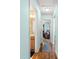 Hallway with wood flooring with a view to the bathroom and an office at 2488 Ansley Path, The Villages, FL 32162