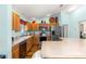 Bright kitchen features wooden cabinets, stainless steel appliances, and a spacious countertop island at 2488 Ansley Path, The Villages, FL 32162
