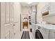 Laundry room with washer, dryer and extra storage with a view to the kitchen at 2488 Ansley Path, The Villages, FL 32162