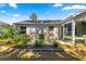 Outdoor patio seating area adjacent to the home with tropical landscaping surrounding the patio at 2488 Ansley Path, The Villages, FL 32162