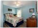 Inviting bedroom with comfortable bed, dresser, and wood flooring at 27121 Greenfly Orchid Ln, Leesburg, FL 34748
