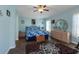 Comfortable bedroom featuring light blue walls, ceiling fan, and cozy furniture at 27121 Greenfly Orchid Ln, Leesburg, FL 34748