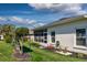 Side view of home featuring a screened lanai, manicured landscaping, and a lush green lawn at 27121 Greenfly Orchid Ln, Leesburg, FL 34748