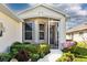 Inviting front porch with decorative plants and view of the front door at 27121 Greenfly Orchid Ln, Leesburg, FL 34748