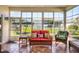 Enclosed sun room featuring wicker furniture and tile flooring at 27121 Greenfly Orchid Ln, Leesburg, FL 34748